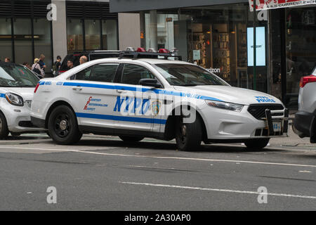 New York City, Circa 2019: NYPD police cruiser car parked on Manhattan road side responding to emergency situation person dial 911 for help and assist Stock Photo
