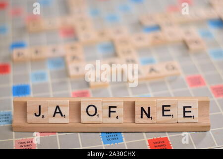 The Dutch word 'ja of nee' (in English: 'yes or no') in wooden scrabble tiles on a rack. The background a vintage board, out of focus, with copy space Stock Photo