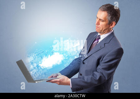 Man holding laptop projecting notifications, symbols and information based on cloud technology system Stock Photo