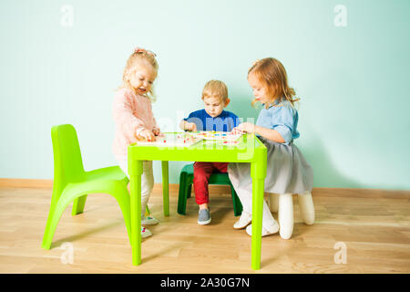 2-3 years old kids playing in kindergarten in Montessori preschool Class. Children learn figures and colours Stock Photo