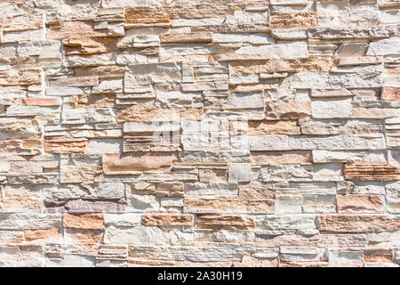Slate stone wall closeup detail of color textures salmon pink cream white background decor outdoors sunlight. Stock Photo