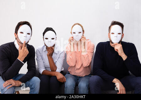 Group Of People Standing Together Covering His Face With White Masks Stock Photo