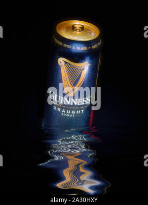 Can of Guinness Draught Stout beer on black background with reflections in water Stock Photo