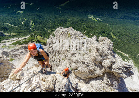 two female mountain climbers on very exposed Via Ferrata in Alta Badia in the Italian Dolomites Stock Photo