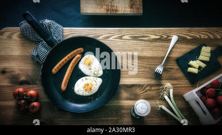 Delicious breakfast eggs in frying pan on rustic wooden table Stock Photo