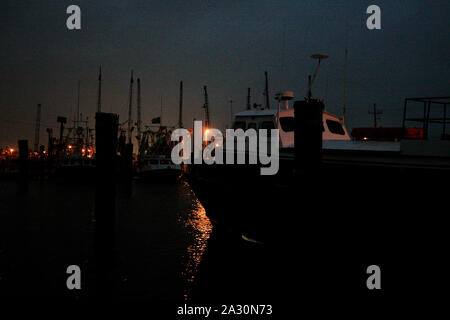 Fishing vessels and a small supply ship lay idle in port in Venice, Louisiana. An oil slick from the Deepwater explosion threatens the wetlands surrounding the Gulf of Mexico. Stock Photo