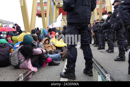 Hamburg, Germany. 04th Oct, 2019. Climate activists block the roadway of the Kattwyk Bridge. About one hundred climate activists have occupied the Kattwyk Bridge in the Port of Hamburg and paralyzed traffic for several hours. Under the motto 'DeCOALonize Europe', they demanded the immediate withdrawal from lignite and hard coal as well as the closure of all coal-fired power plants in Hamburg and the coal port in Hamburg. (to dpa 'Protest against coal-fired power plant Moorburg - activists occupy bridge') Credit: Magdalena Tröndle/dpa/Alamy Live News Stock Photo