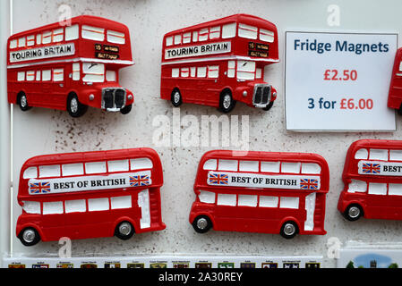 Iconic Red Double-Decker London Buses. Souvenir Badges or Fridge Magnets For Sale on Souvenir Stall London England UK