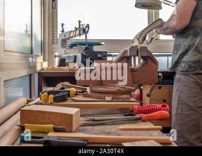 Man working in a carpentry workshop and crafting a wooden model Stock Photo
