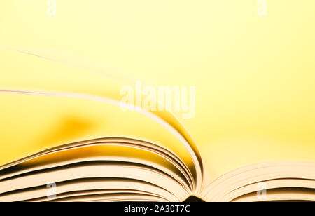 Book pages turning over yellow background. Pages flipping over.  Stock Photo