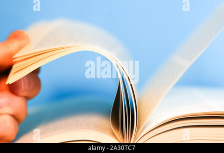 Hand flipping through pages of a book. Book pages turning Stock Photo