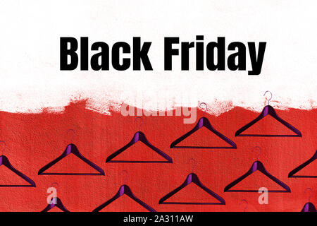 Black Friday sale concept with fashion clothes hanger pattern on red and white color wall background. Shopping. Outfit. Flat lay, top view. Stock Photo