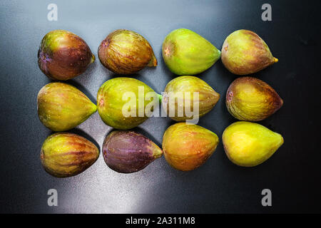 Fresh ripe figs on black background. Pattern, top view, flat lay, close up. Tropical fruit. Stock Photo