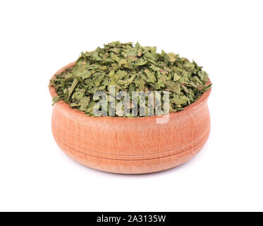 Dried cilantro in wooden bowl for spices isolated on white background. Crushed cilantro. Dried parsley leaf. Closeup Stock Photo