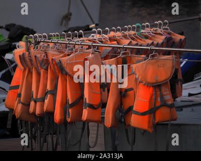 life jackets hanging on a clothes rack Stock Photo
