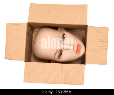 Horizontal shot of a bald woman mannequin head inside an open cardboard box. The box is turned so the head is sideways.  White background. Stock Photo