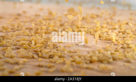 Bulgur raw grits in a pile with grains falling from above Stock Photo