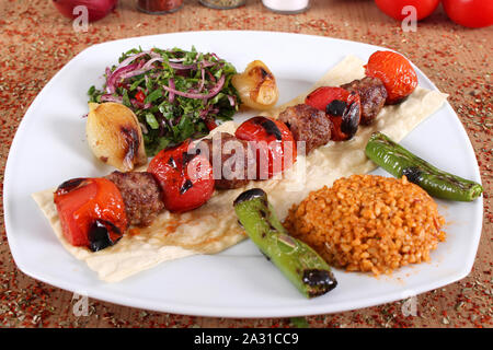 Meat and tomato kebabs peppercorns and vegetables Stock Photo