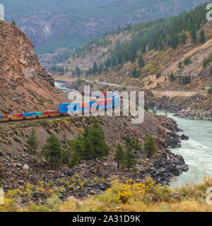Canadian National freight train carrying colourful containers to Vancouver through the Thompson River valley in British Columbia seen from the Rocky M
