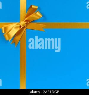 Gold bow gift ribbon blue background Stock Photo