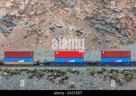 Canadian National freight train carrying colourful containers to Vancouver through the Thompson River valley in British Columbia seen from the Rocky M Stock Photo