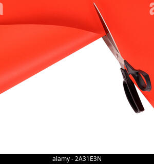 Scissors cutting red paper background Stock Photo