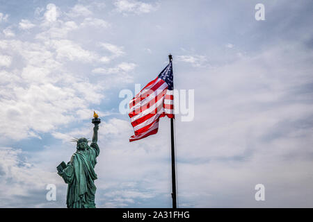 The Statue of Liberty and the US flag, New York City, USA. Stock Photo