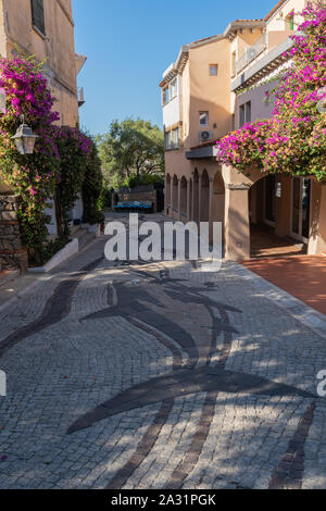 Quiet deserted narrow street in Porto Rotondo Sardenia with flowers and artistic pavement Stock Photo