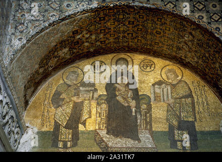 Istanbul, Turkey. The Hagia Sophia. Mosaic depicting the Virgin Mary, holding Jesus, flanked by Emperors Constantine the Great (on the right) holding a model of the city of Constantinople, and Justinian I (on the left) holding a model of Hagia Sophia.  Tympanum above the Southwestern entrance, 944. Stock Photo
