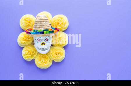 Skull with Mexican hat surrounded by yellow paper tagetes. Day of the Dead. Copy space Stock Photo