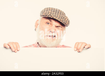 Senior bearded emotional man peek out of banner place announcement. Elderly person. Announcement concept. Event announcement. Pensioner grandfather in vintage hat poster information copy space. Stock Photo
