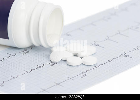 Daily aspirin with electrocardiograph on white. Stock Photo