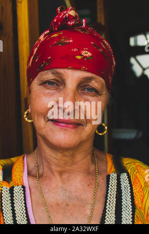 Beautiful old Berber woman from the Aures region with Green eyes, smiling and wearing traditional chaoui headscarf. Stock Photo