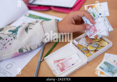 Munich, Germany. 24th Sep, 2019. A student in a 2nd grade is counting on play money in the classroom of a primary school. Due to the lack of teachers in Bavaria, fewer and fewer fully trained special education teachers teach at the special needs schools. Credit: Sven Hoppe/dpa/Alamy Live News Stock Photo
