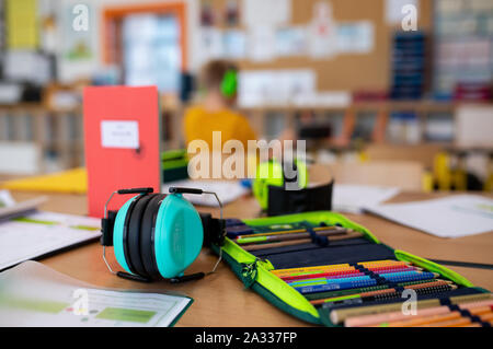 Munich, Germany. 24th Sep, 2019. A pencil case and hearing protection are lying on a table in the classroom of a 2nd class of a primary school. Due to the lack of teachers in Bavaria, fewer and fewer fully trained special education teachers teach at the special needs schools. Credit: Sven Hoppe/dpa/Alamy Live News Stock Photo