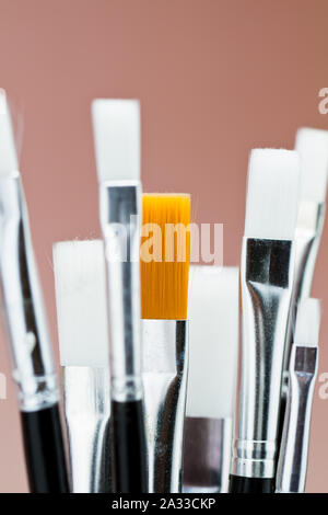 a brown drawing brush among few white drawing brush Stock Photo