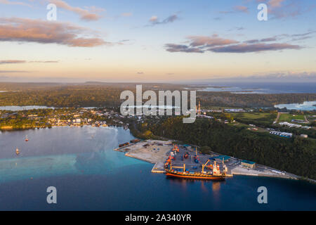 Aerial view of a container ship loading cargo in the commercial dock of Port Vila, Vanuatu capital city in the south Pacific at sunset Stock Photo