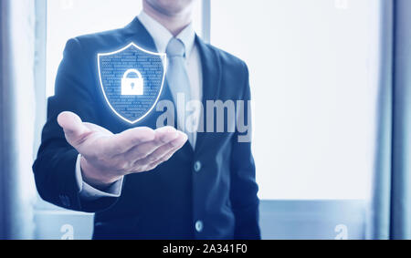 Protection business network and digital data. Businessman holding shield with lock icon Stock Photo
