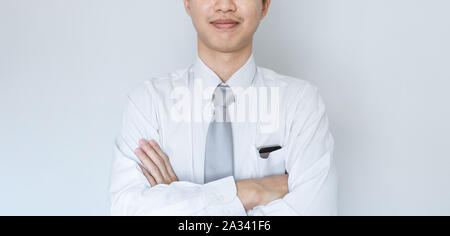 Business employee smiling in white shirt with arm crossed Stock Photo
