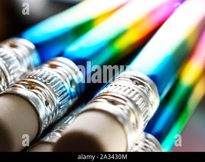 Beautiful Angled View of Aluminum Caps and White Eraser Heads on Rainbow Foiled Pencils. Stock Photo