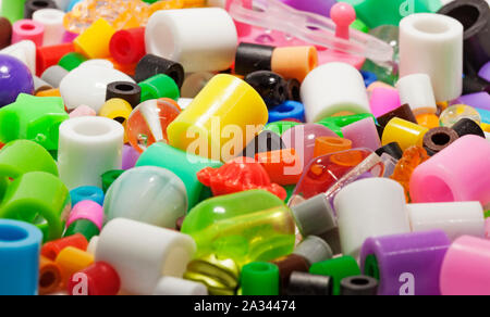 mixed beads in different colors and shapes on white background with studio lights Stock Photo