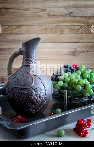 Grapes and wine in a jug on the table Stock Photo