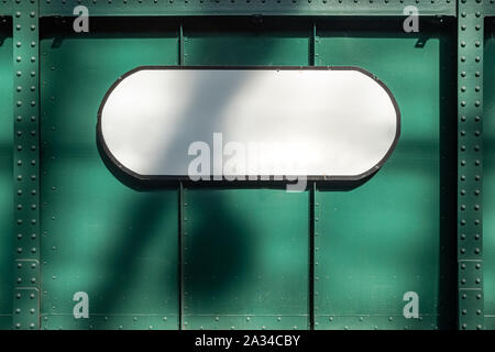 White plate at abstract green metal textured background with rivets and bolts Stock Photo