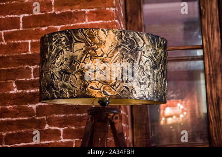 Handmade table lamp with bronze floor lamp. Lighting in a cozy interior. Texture paste and bronze paint for decoration. Stock Photo