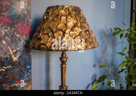 Handmade table lamp with bronze floor lamp. Lighting in a cozy interior. Texture paste and bronze paint for decoration. Stock Photo