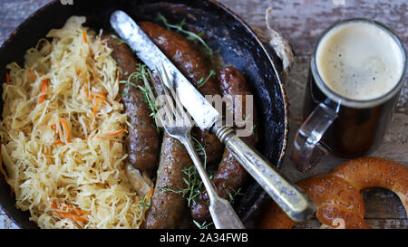 Oktoberfest food. Hot Bavarian sausages with sauerkraut in a pan. Delicious beer festival food Stock Photo