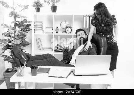 Offer massage. Man bearded hipster boss sit in leather armchair office interior. Boss and secretary girl at workplace. Relations at work. Business people and staff concept. Lazy boss office. Stock Photo