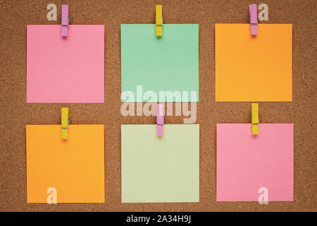 Colorful stickers on the clothespin on cork board, wood background. Concept of planning. Note for writing. Sticky notes, blank paper. Copy space Stock Photo