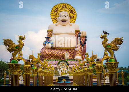 Giant smiling or happy buddha statue with blue sky in buddhist temple ( wat plai laem ), Koh Samui, Thailand. Stock Photo