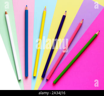 Colored pencils are spread out in fan pattern on a colored background, which is also located in a fan pattern Stock Photo